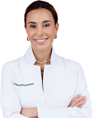 Woman wearing a white coat with 'Dr. Maryam Zamani' on it against a white background